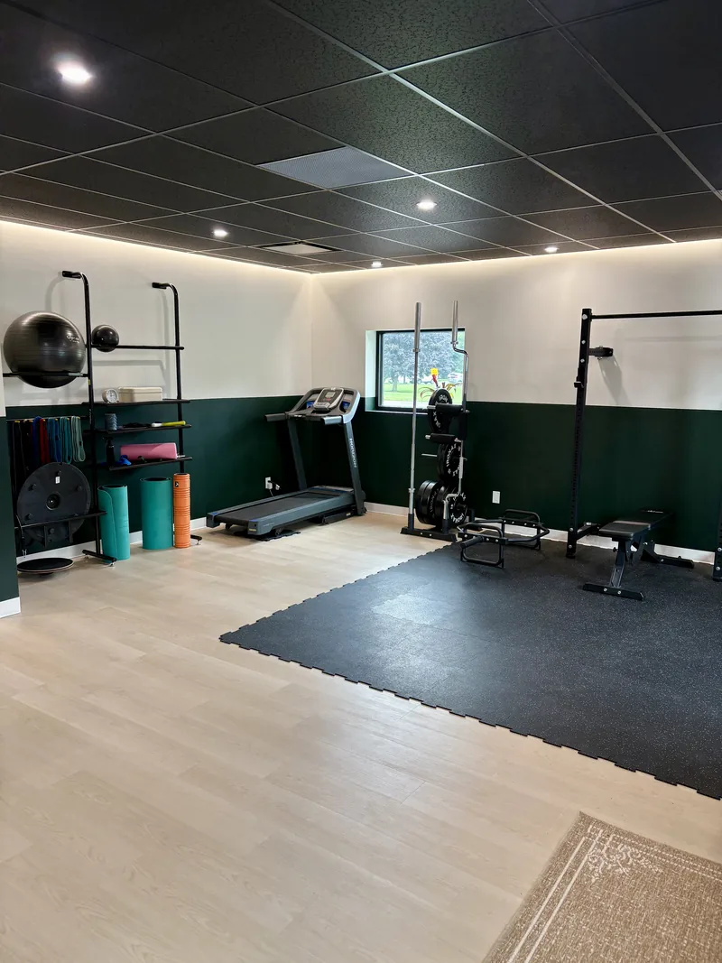 Rehab gym with squat rack, treadmill, bench and mobility equipment at Achieve Movement Health Clinic in Simcoe, Ontario
