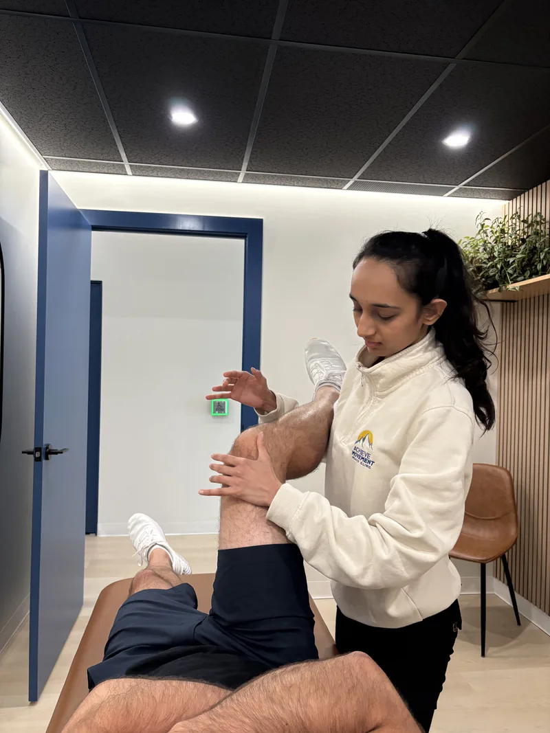 Clinician providing hands-on treatment on a patient's knee at Achieve Movement Health Clinic in Simcoe, Ontario