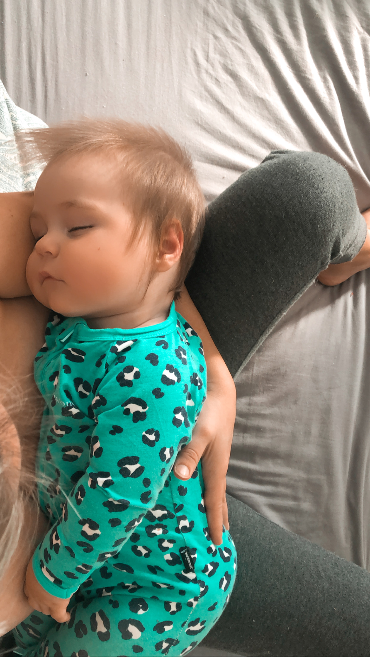 Baby contact napping asleep on mum's lap at home
