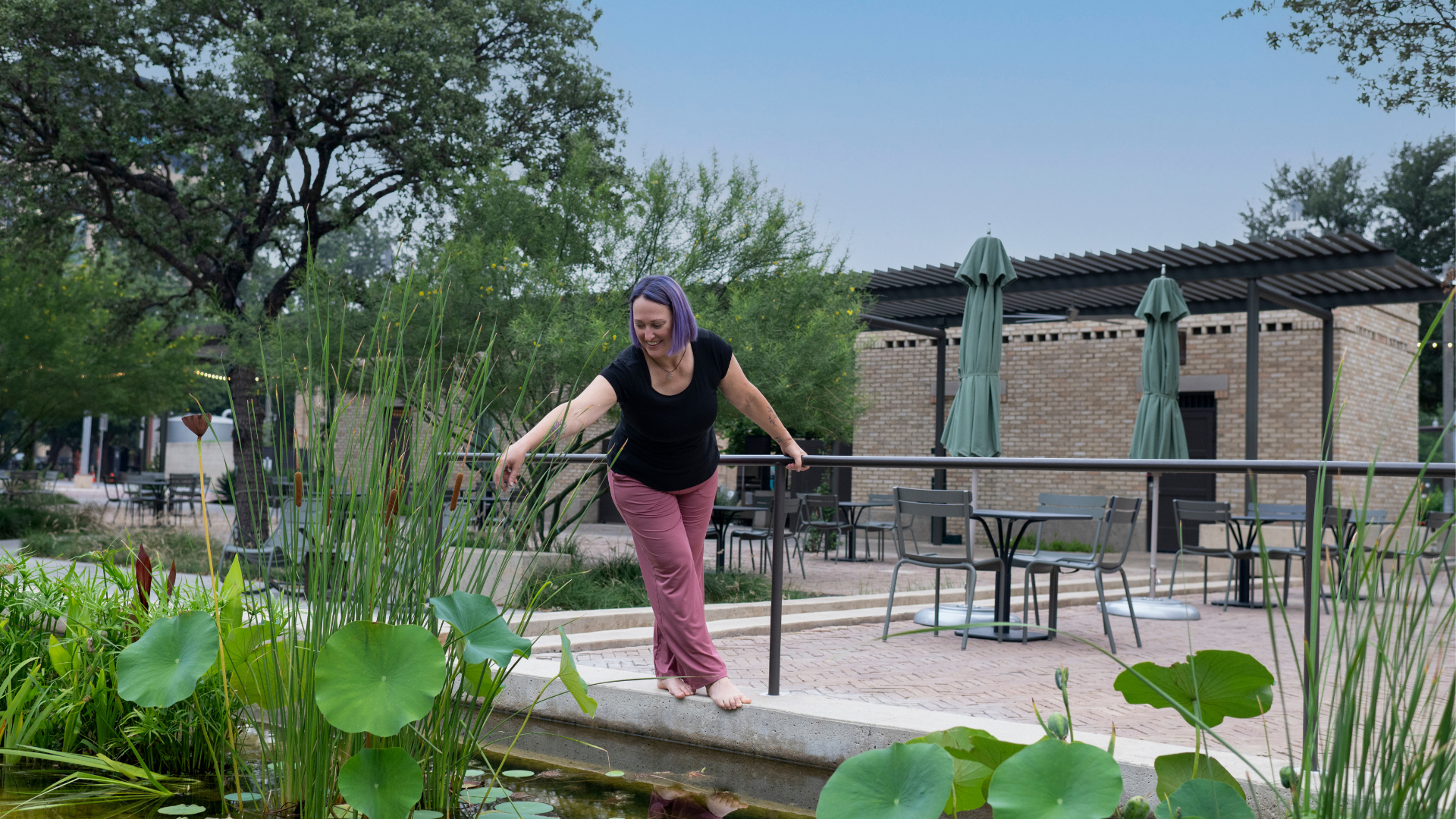 author standing on edge of water feature with arm reaching out author standing on edge of water feature with arm reaching out
