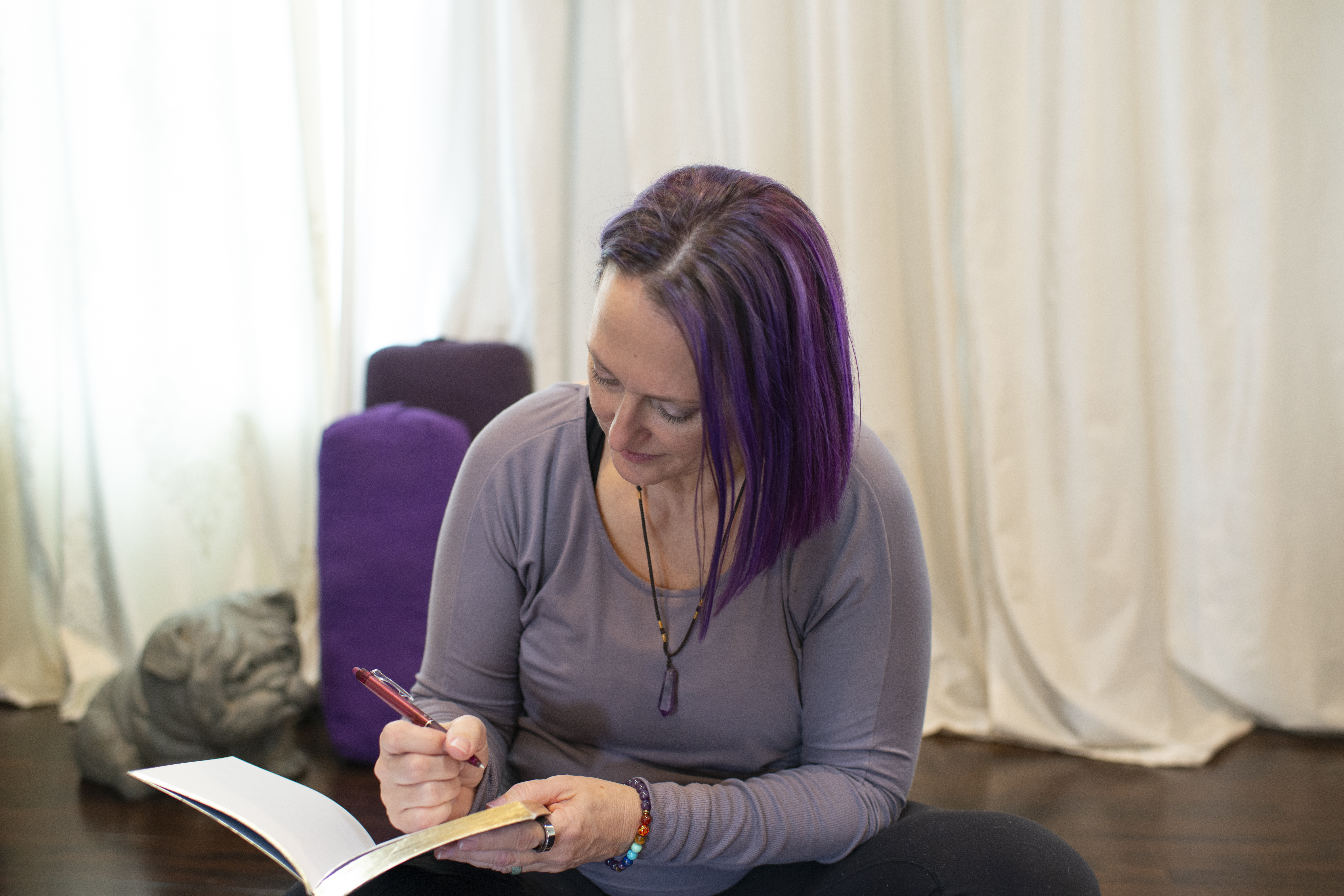 author sitting on floor writing in journal