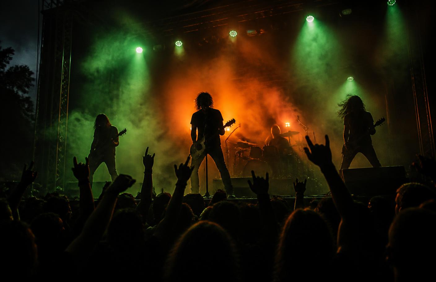 Band performing under green and orange stage lights