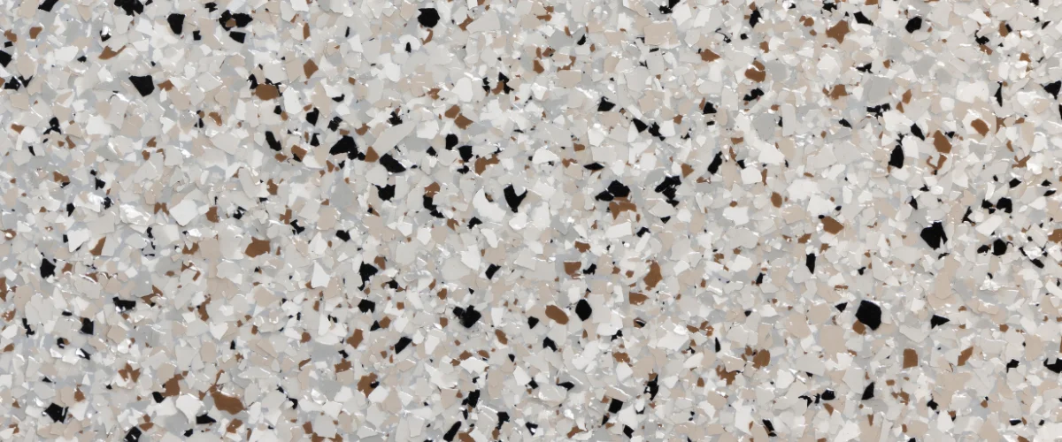 Decorative quartz chips in black, brown, white, and gray colors scattered evenly across a surface.