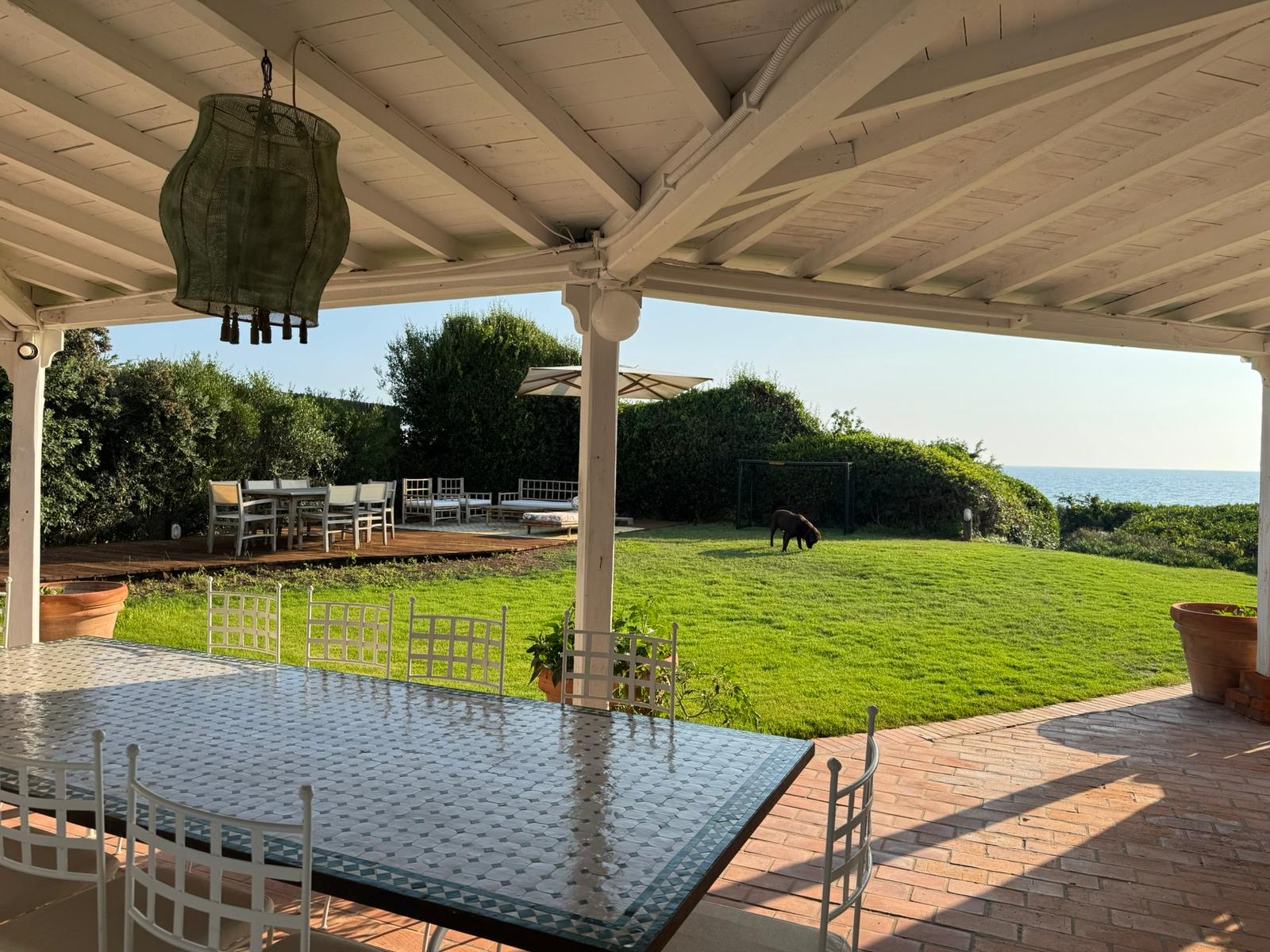 Portico con tavolo in mosaico e giardino affacciato sul mare — villa a Sabaudia