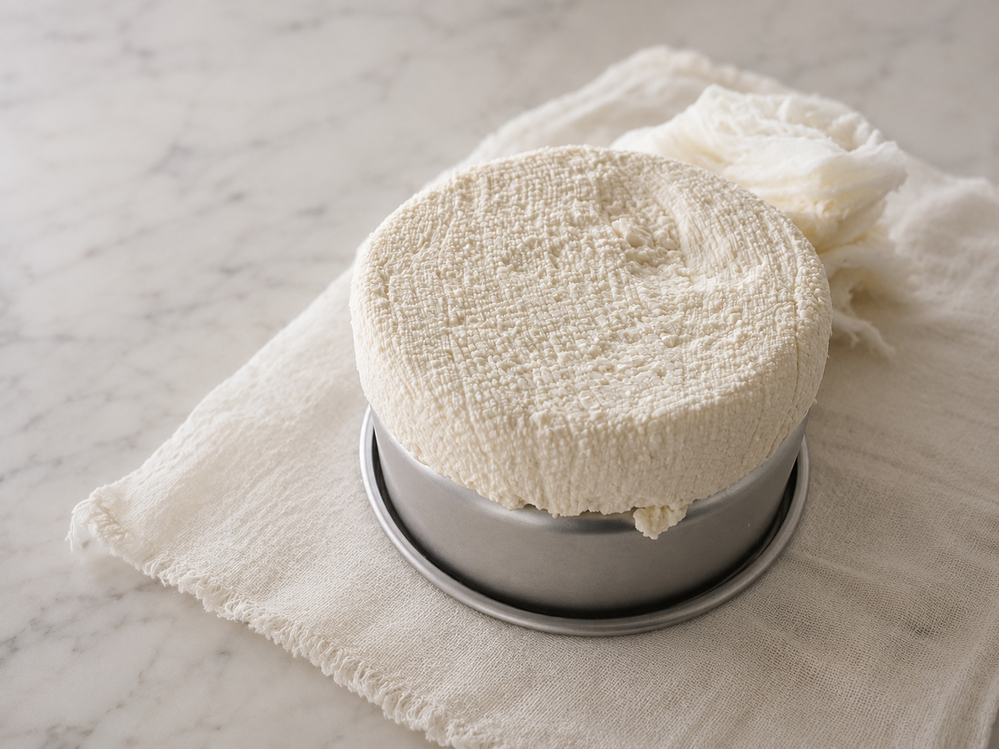 Fresh homemade cheese prepared for a simple charcuterie board with crackers, fruit, and meats for a family picnic. Fresh homemade cheese prepared for a simple charcuterie board with crackers, fruit, and meats for a family picnic.