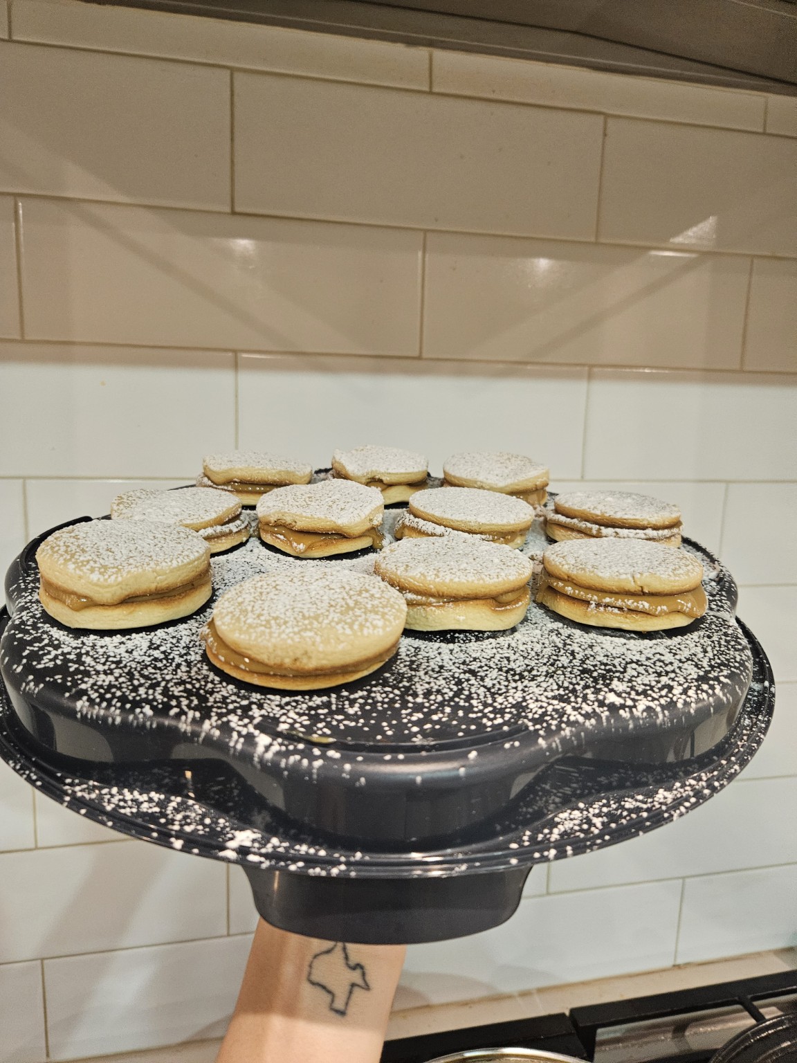 Homemade alfajores filled with dulce de leche and dusted with powdered sugar by Mariposas LLC