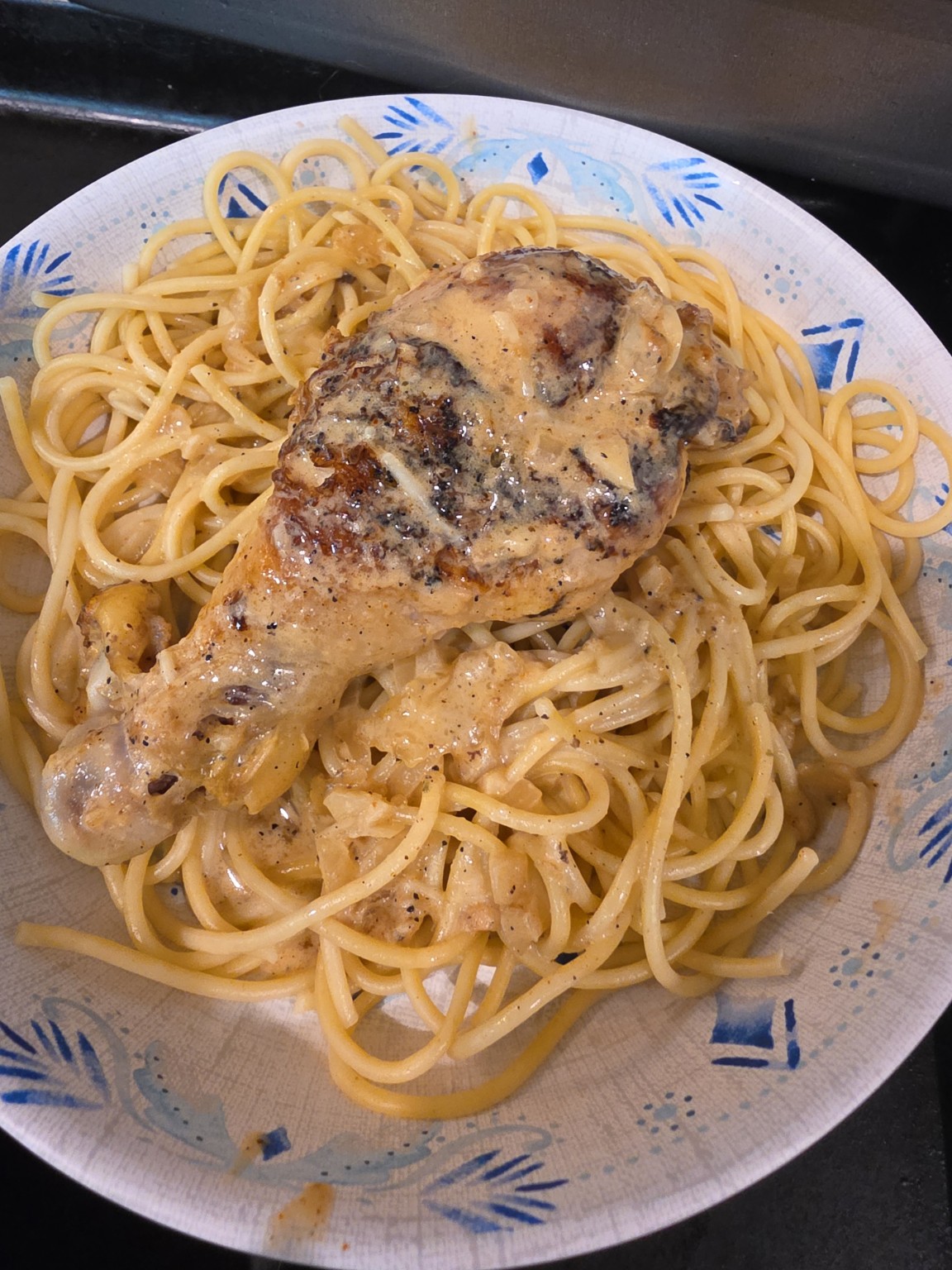 Creamy garlic Parmesan spaghetti topped with a butterflied chicken drumstick and homemade onion garlic sauce.