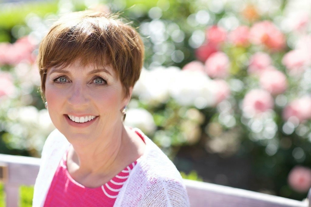 Laurette DeJulian smiling in a rose garden