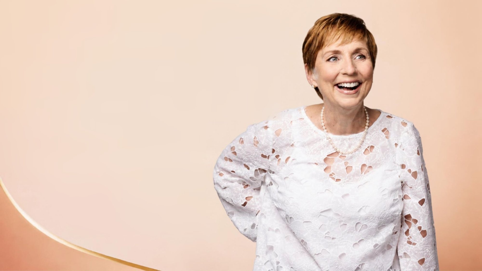 Laurette DeJulian laughing, in a white lace top and pearls