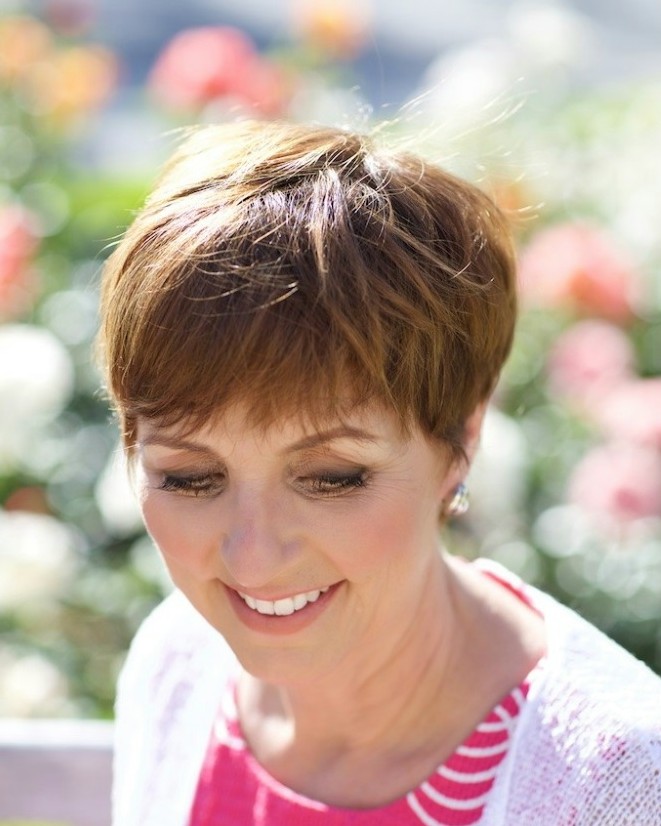 Laurette DeJulian smiling in a rose garden
