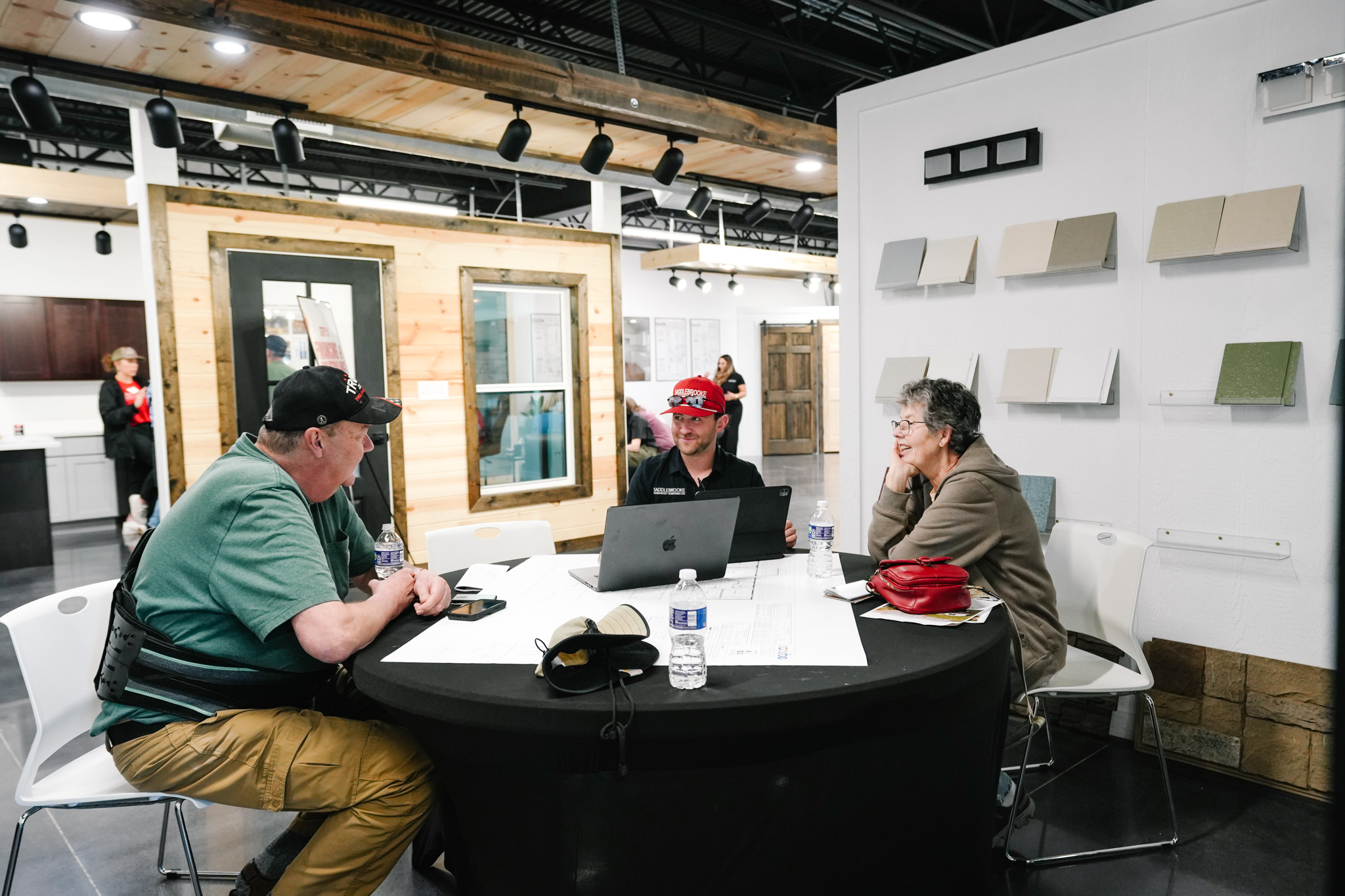 Saddlebrooke team member helping a couple compare build offers in the showroom