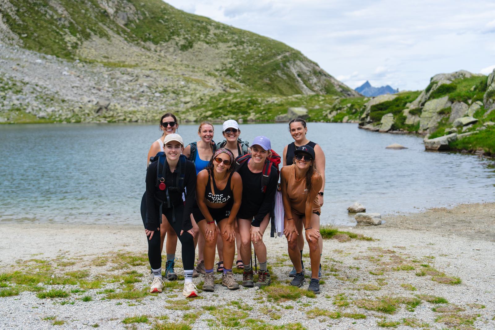 A group of hikers posing by a mountain lake
