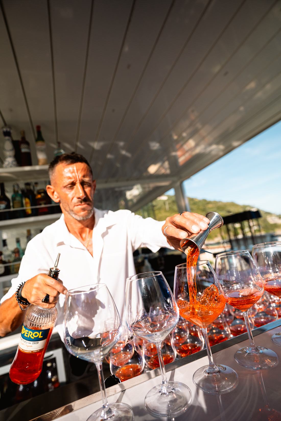 A bartender pouring drinks for a group on a terrace