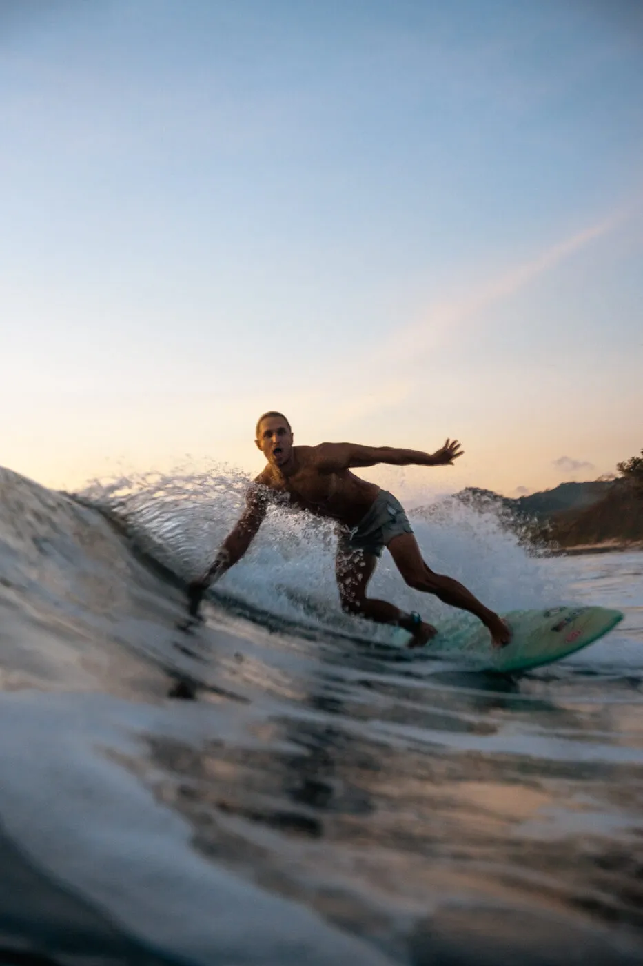 Surfer riding a wave at sunset, Playa Maderas