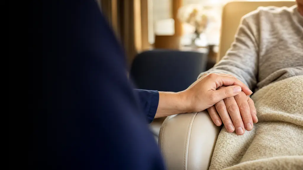 A clinician’s reassuring hand on a patient’s hand during treatment