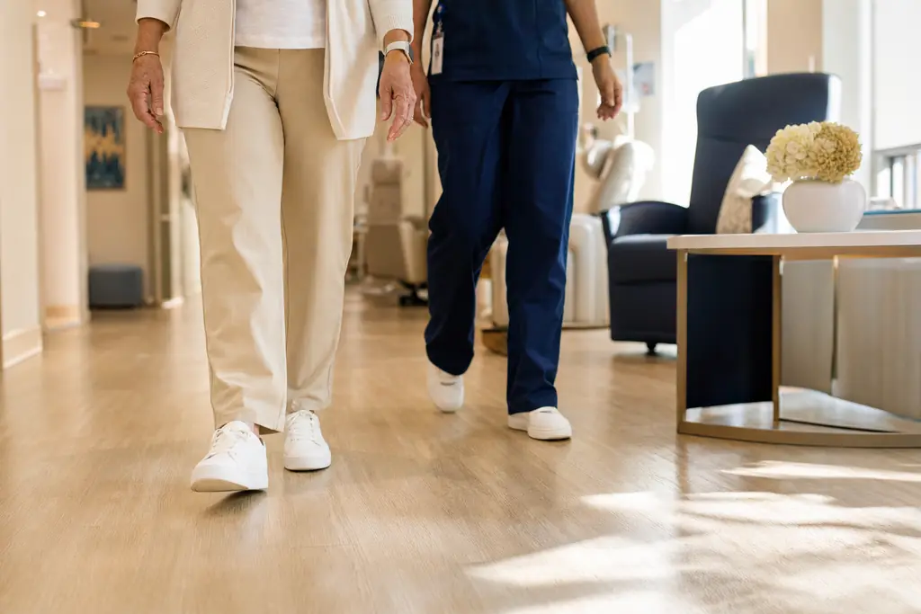 Patient walking steadily down a sunlit clinic hallway