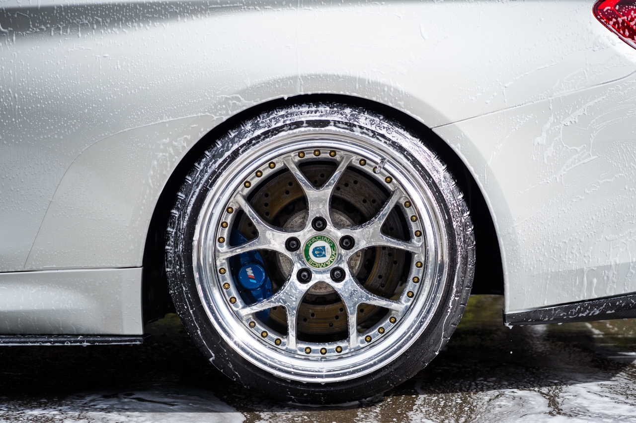 A foamed wheel and tyre mid-wash during an exterior detail by Envy Premium Detailing