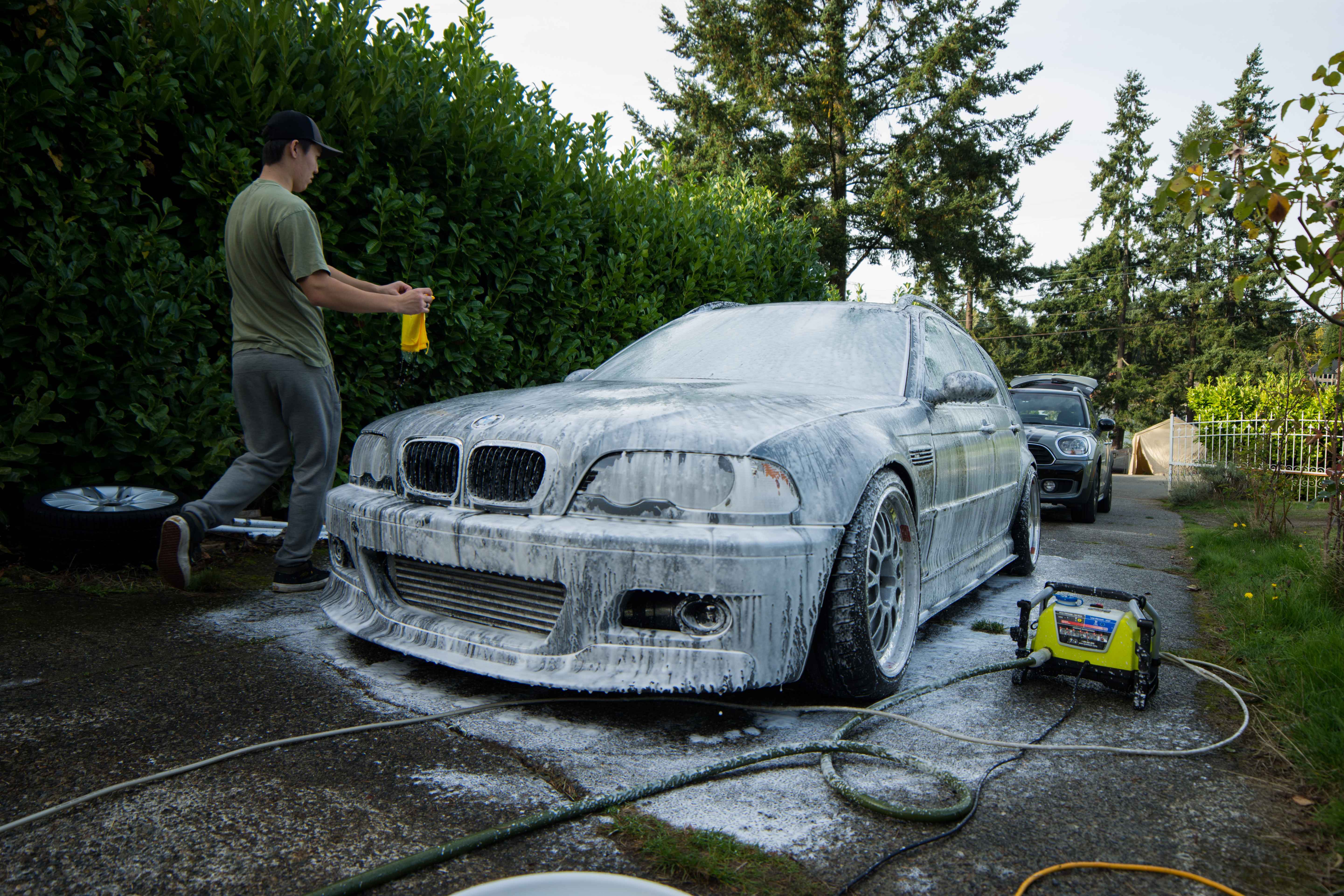 A BMW E46 wagon covered in snow foam part-way through a hand wash at the Envy Premium Detailing studio in Redmond, WA