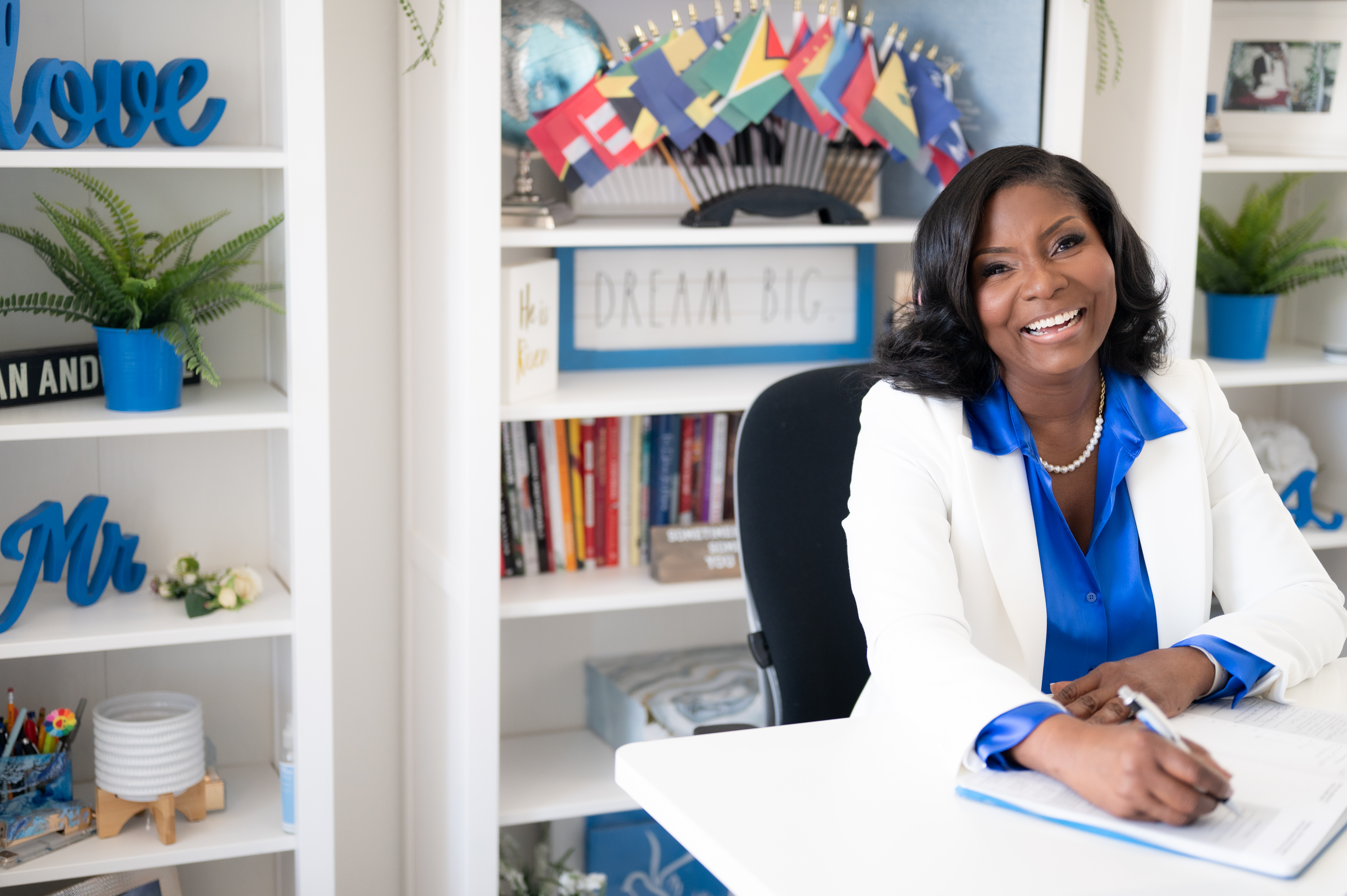 Coach Michelle smiling in her white jacket and royal-blue blouse