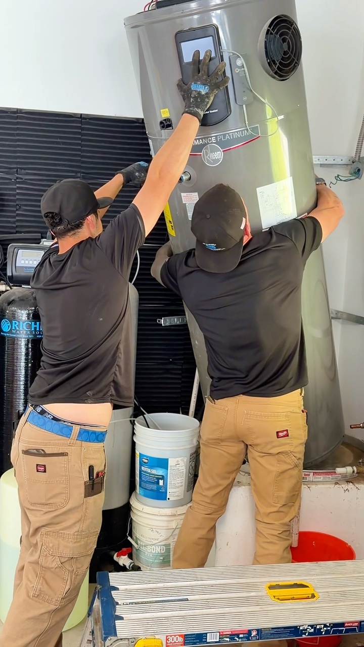 Plumbers installing a water heater
