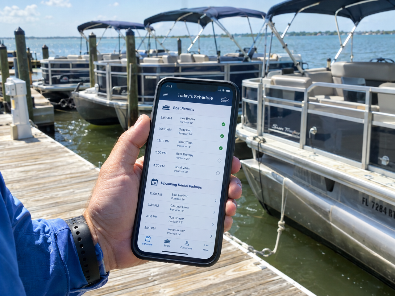 Dock hand checking boat rental return times and upcoming pickups on a mobile phone at a sunny marina