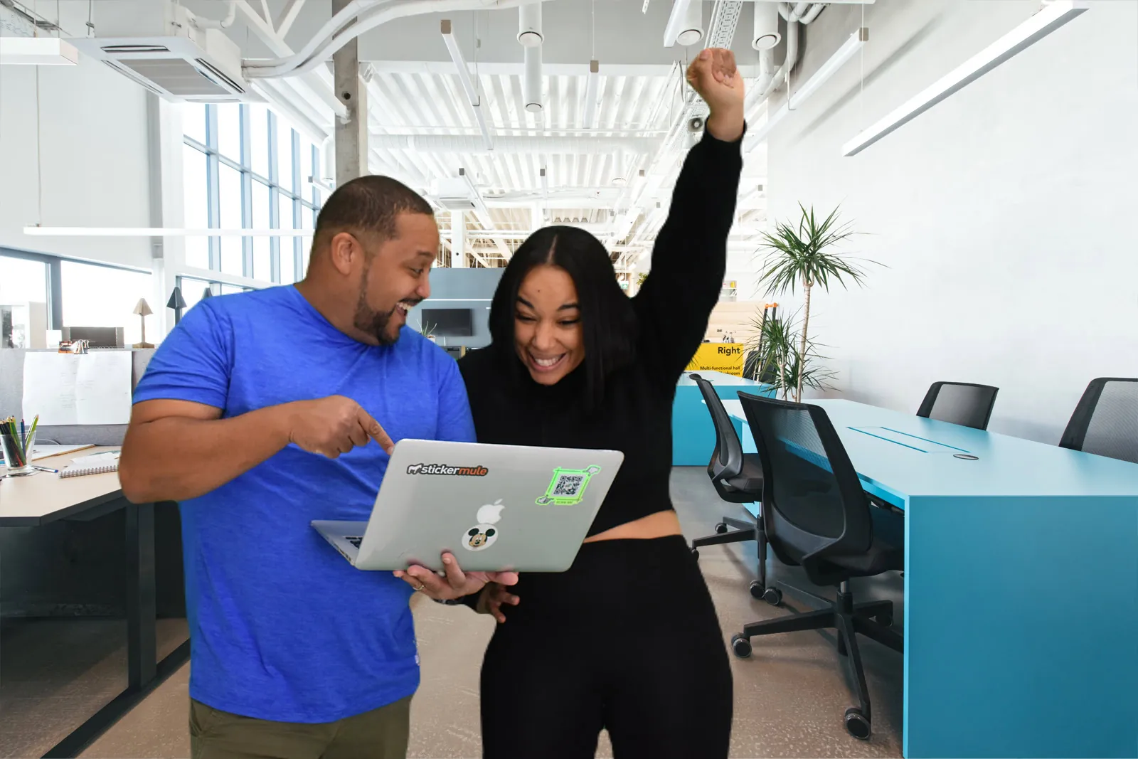 Preston Martelly, founder of JavaLogix, pointing at a laptop screen as a smiling client raises her fist
