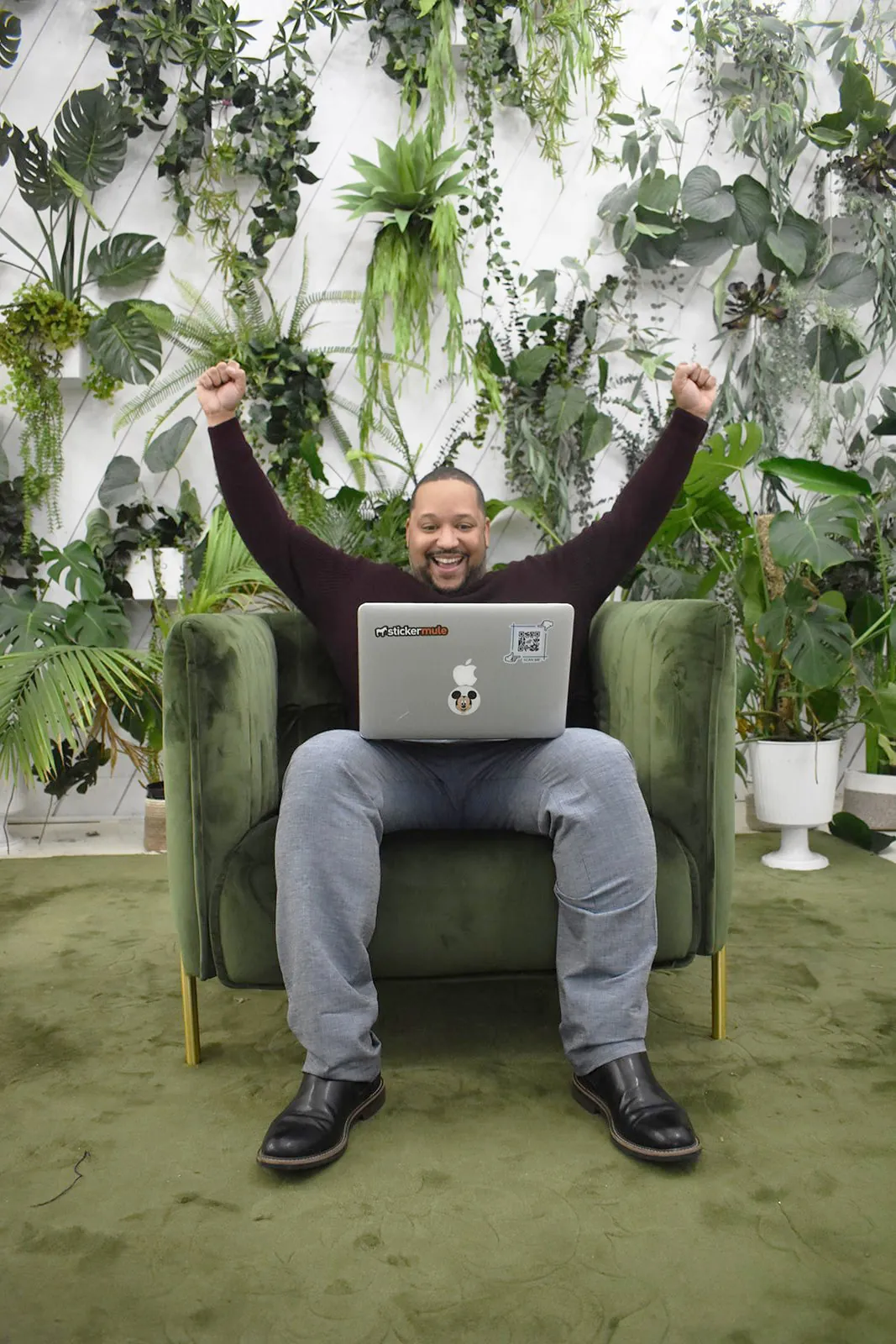 Preston Martelly, founder of JavaLogix, cheering with both arms up behind his laptop