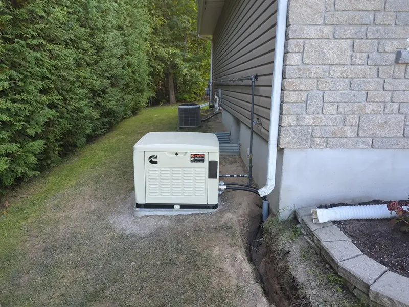 A standby generator installed by Safeguard Electric beside a house, its new cable trench still open
