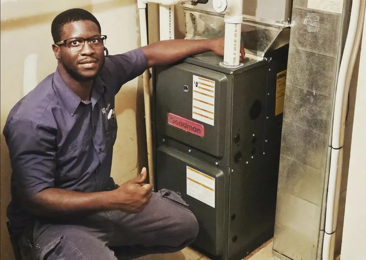 Fabian Atkins beside a newly installed Goodman furnace