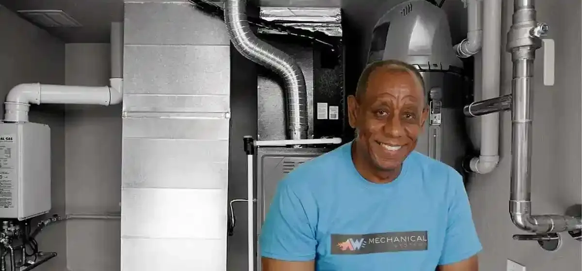 Tony Waithe in a furnace room in an AW Mechanical Systems shirt