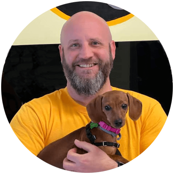 Drew Brashier, owner of Paw & Order Upstate SC, holding a dachshund