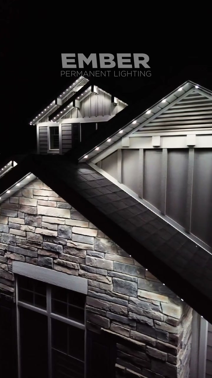 Individually addressable Ember LED roofline lights glowing along the peaks of a home at night