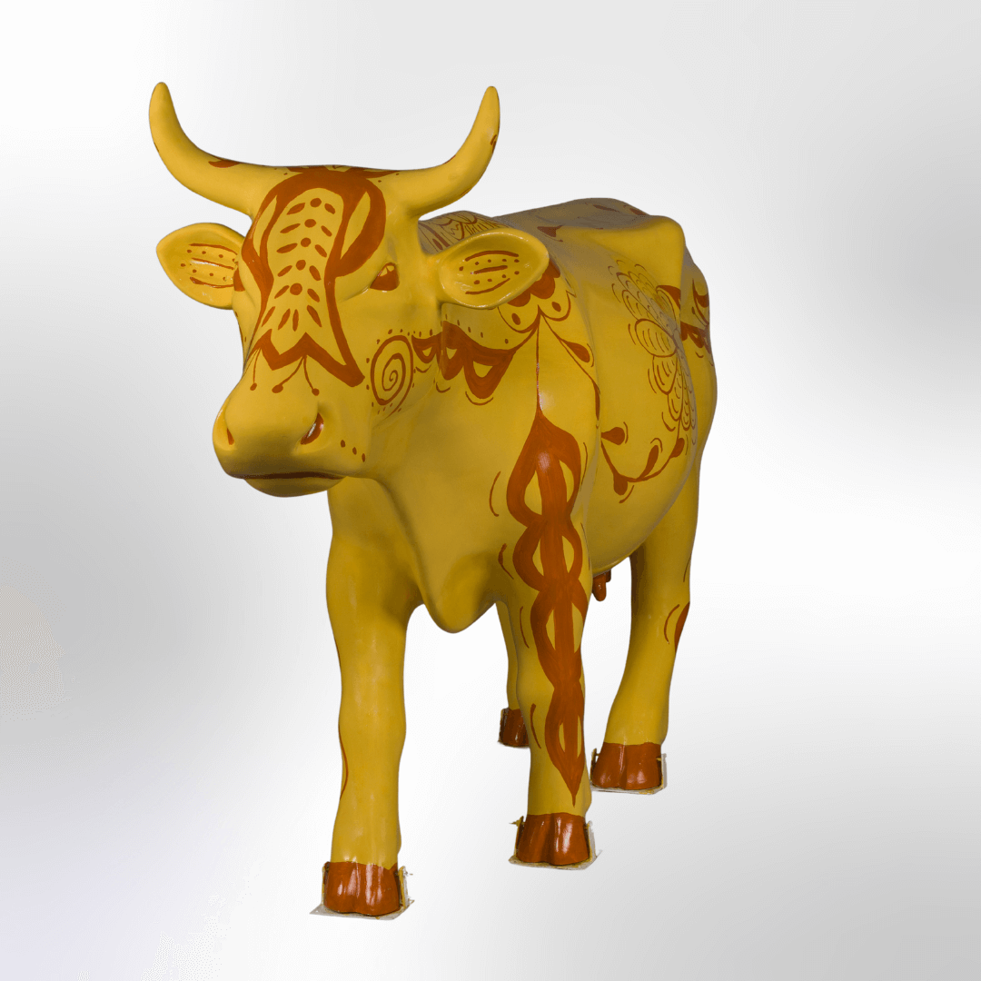 A cow covered in folk art designs like grafitto pottery