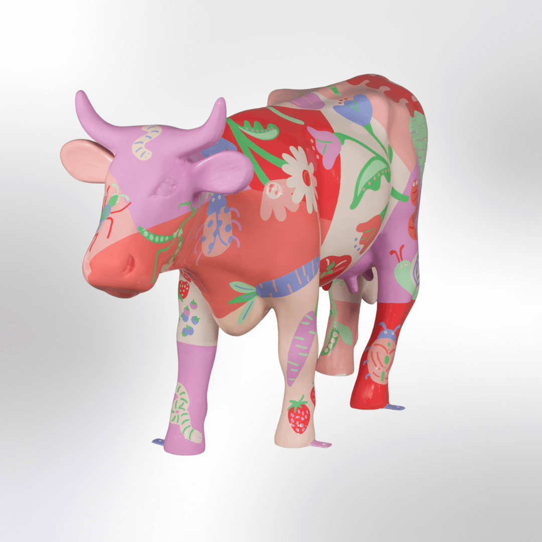 A pastel cow covered in flowers, fruits, and pollinators