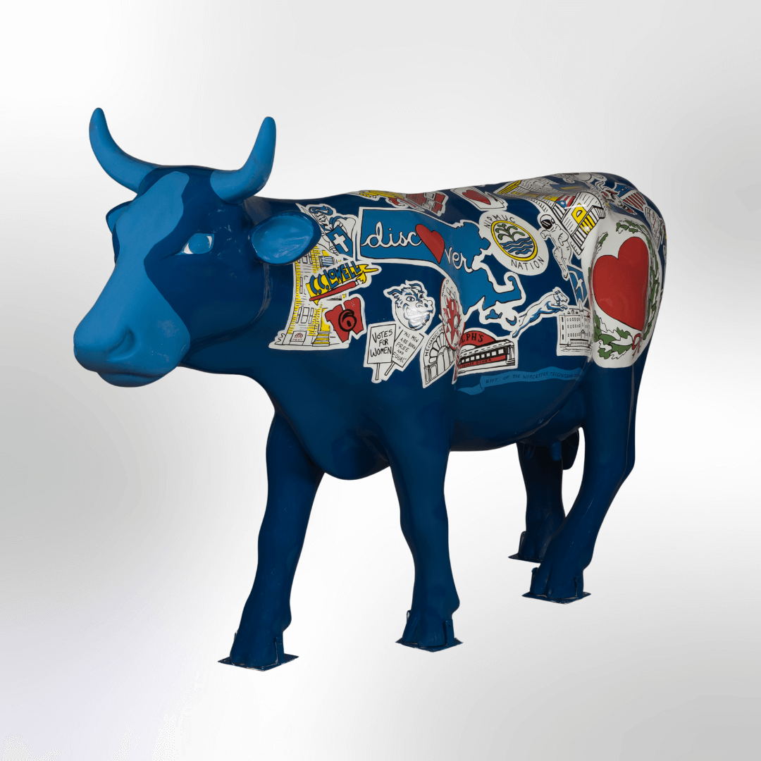 A blue cow covered in logos, signs, and sites related to Worcester, MA, such as a smily face and heart