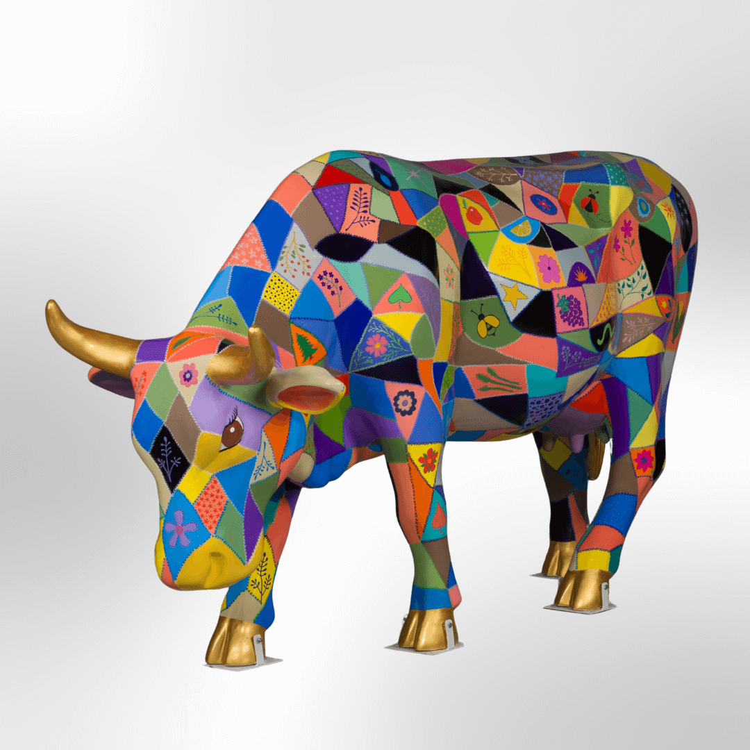 A colorful cow covered in a crazy quilt motif