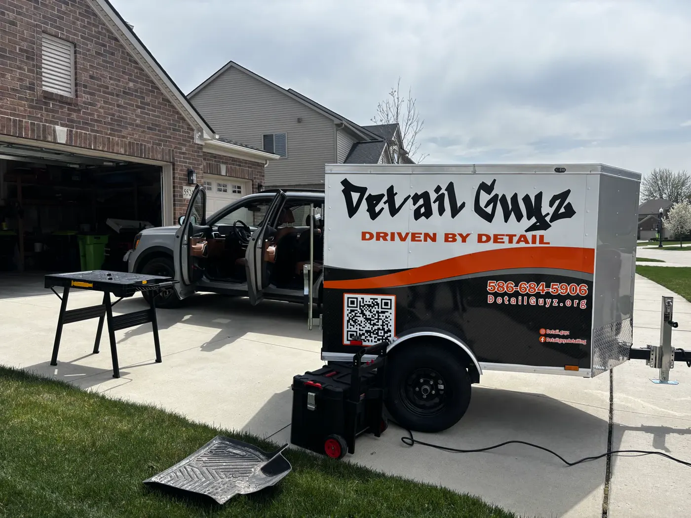 The Detail Guyz trailer set up on a driveway job