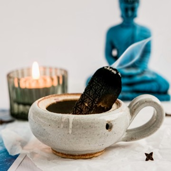 Intentional ceremonial setting with candle, ritual bowl, and Buddha figure