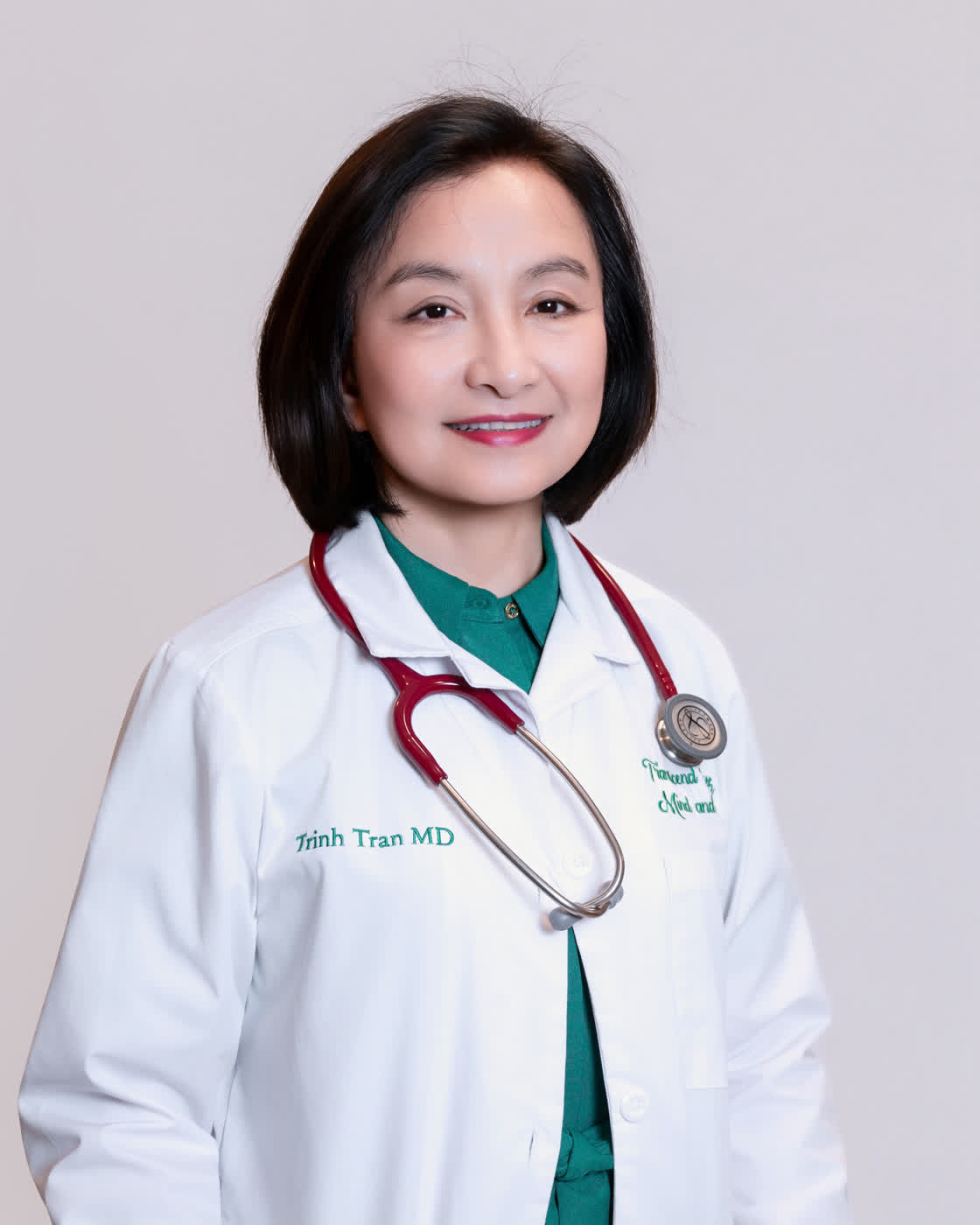 Trinh Tran MD, rheumatologist, in her white coat.