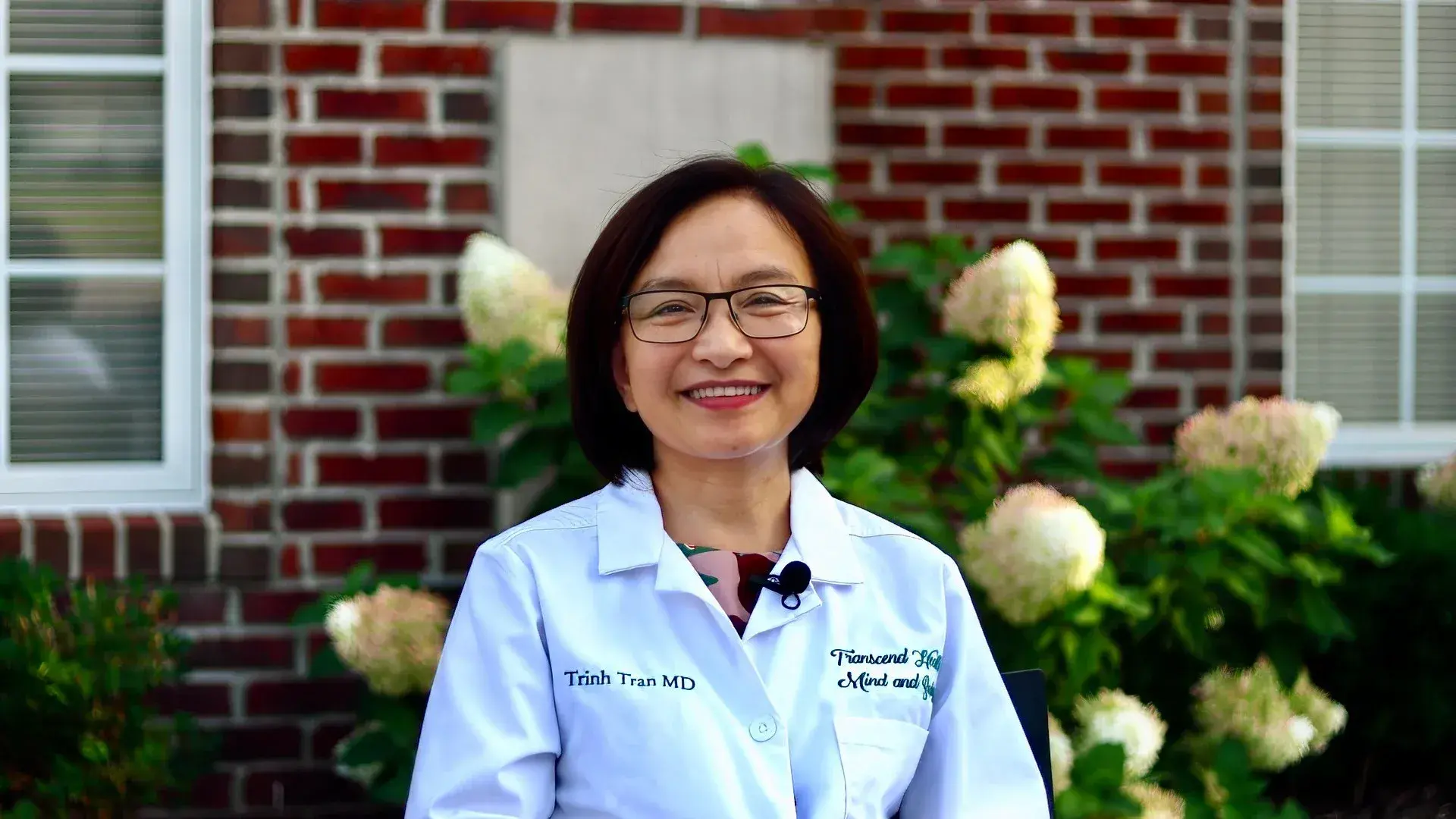 Trinh Tran MD, rheumatologist, seated.