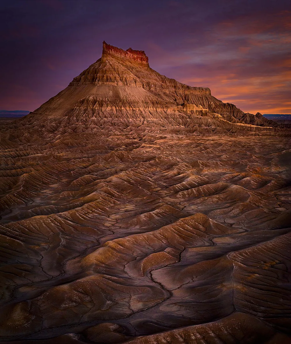 Factory Butte rising from the Utah desert at dusk