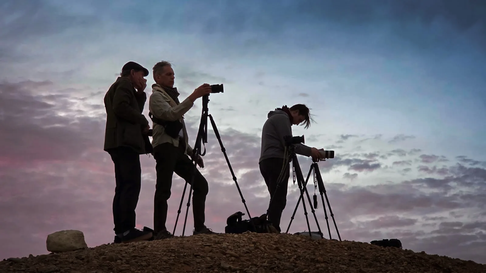 Greg Koorhan teaching a small group of photographers on a hilltop at dusk