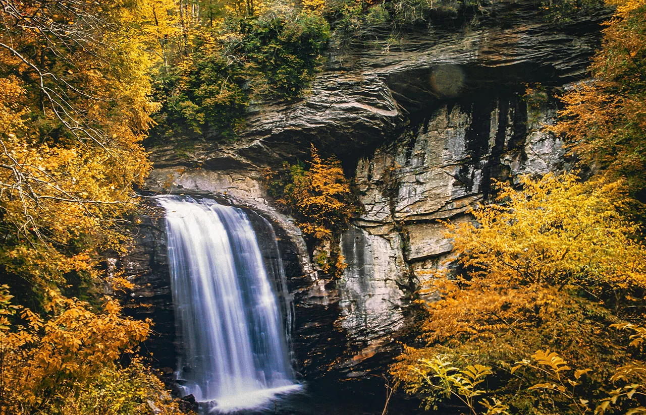 Looking Glass Falls cascading over rock beneath autumn foliage near Asheville, North Carolina