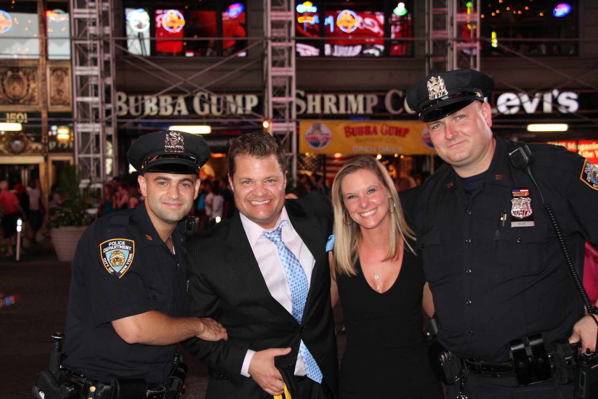 Storm Bennett and his wife Heather Bennett posing with NYPD officers in New York City