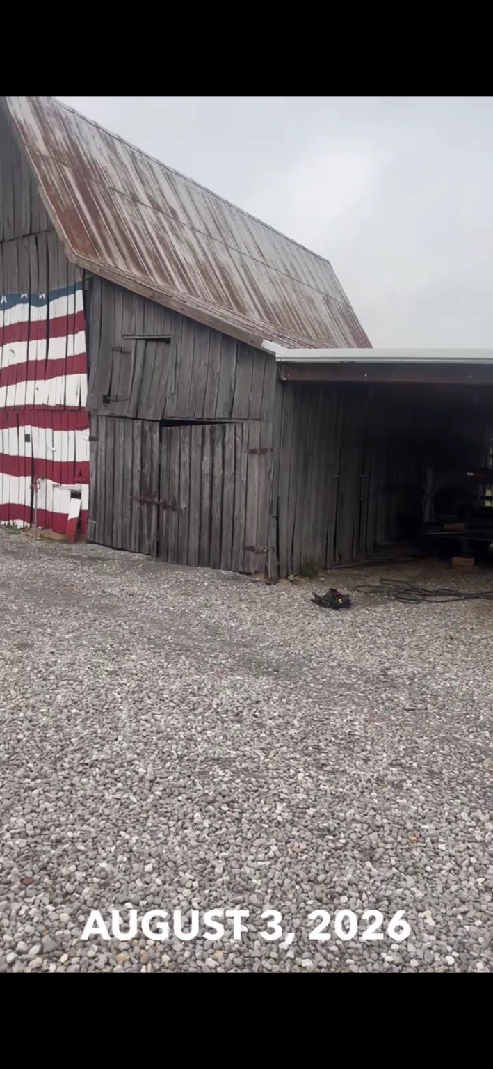 JT's Flag Barn — Crew working around the painted flag during siding replacement