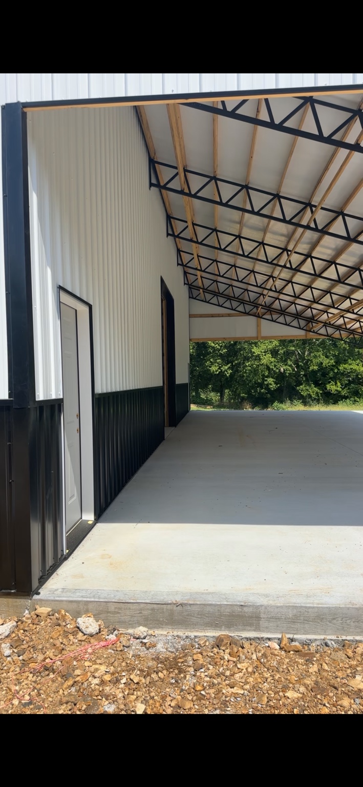 White-and-black metal exterior of a completed agricultural shop building in Middle Tennessee
