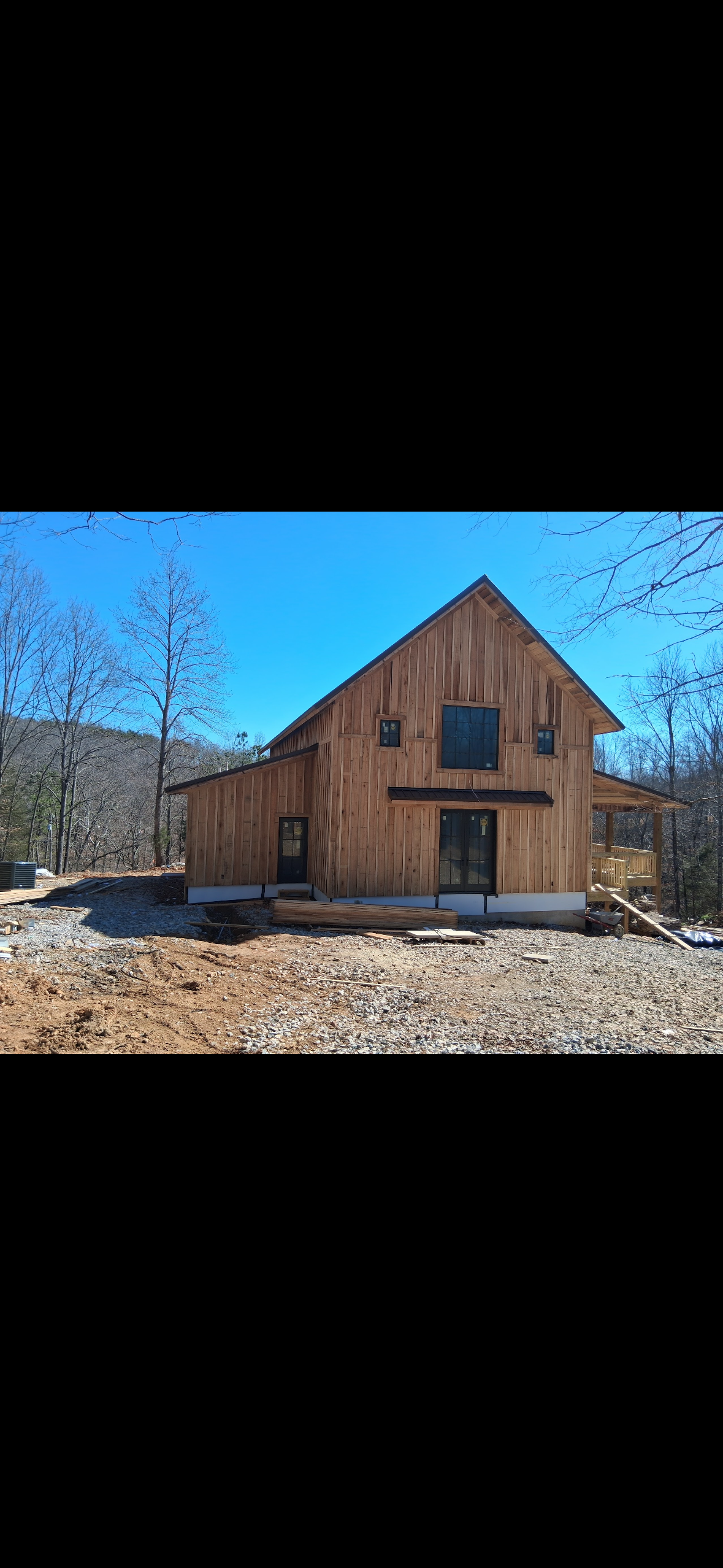 Rural custom home with wood construction, metal roof, and covered porch in Middle Tennessee