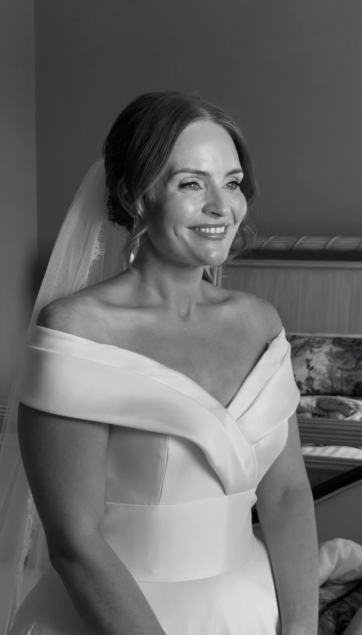 Bride smiling in an off-the-shoulder dress