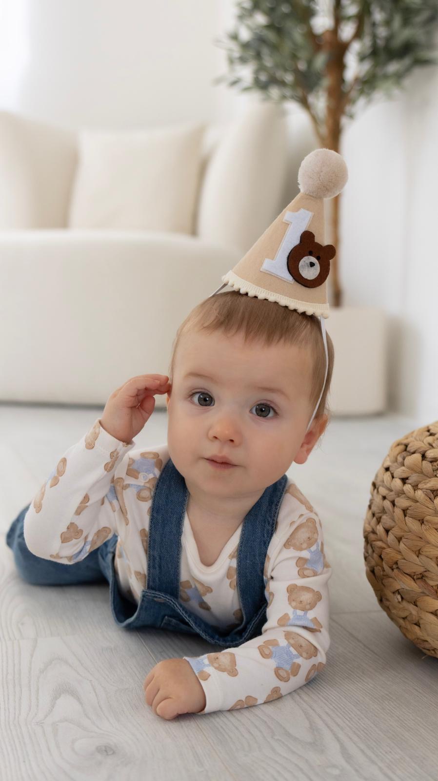 Baby in a first birthday party hat