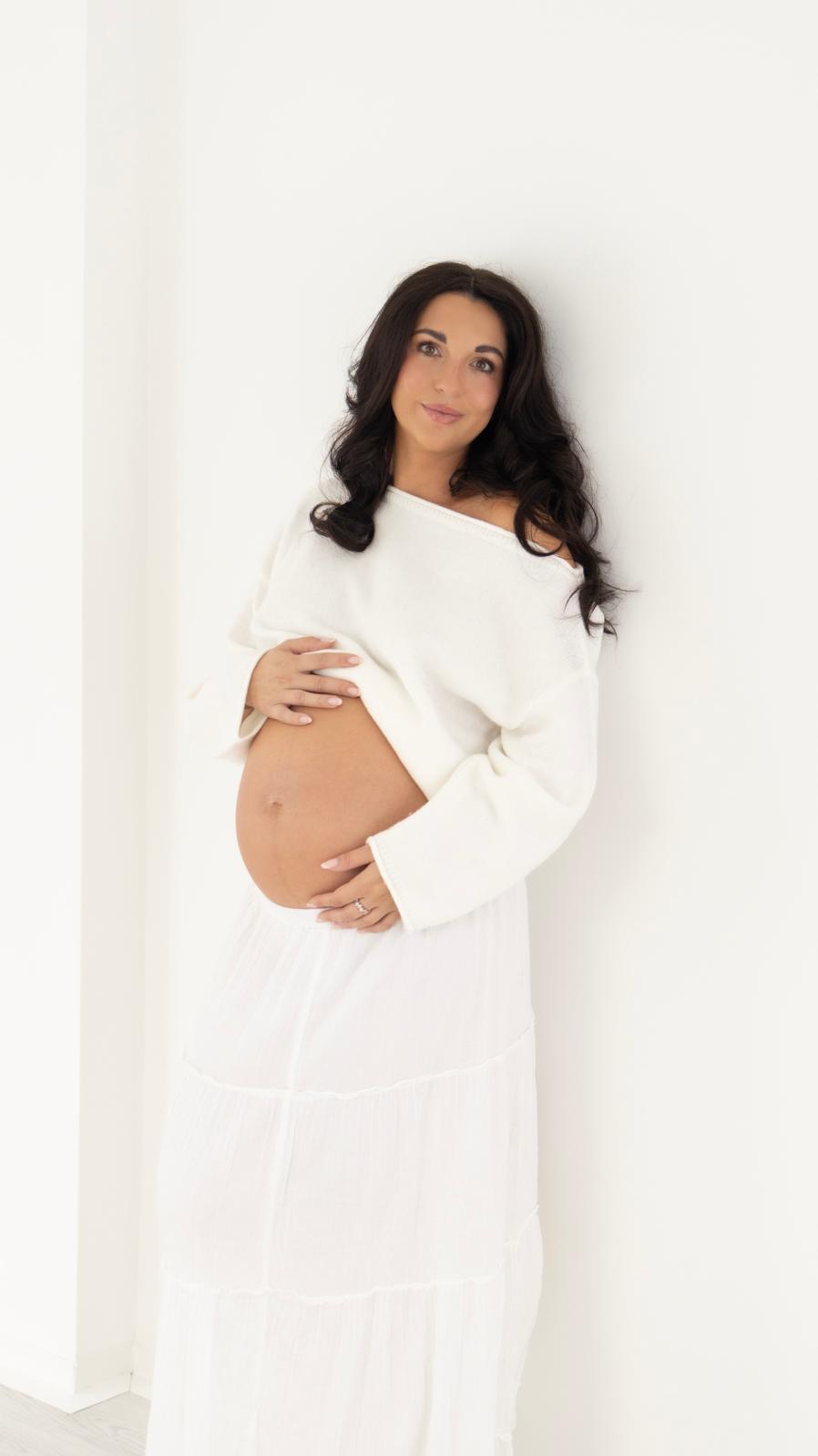 Maternity portrait in a white knit jumper and skirt
